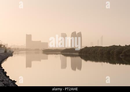 27 August 2018: Al Bahr Towers and Mangroves reflection in the sea, Abu Dhabi UAE Stock Photo