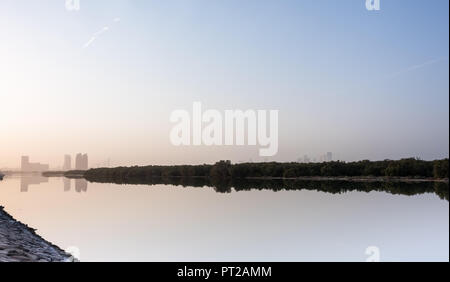 27 August 2018: Al Bahr Towers and Mangroves reflection in the sea, Abu Dhabi UAE Stock Photo