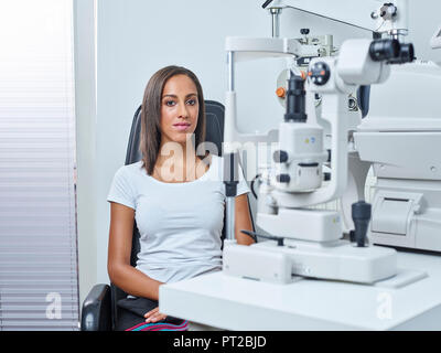 Optician, Young woman before eye test Stock Photo