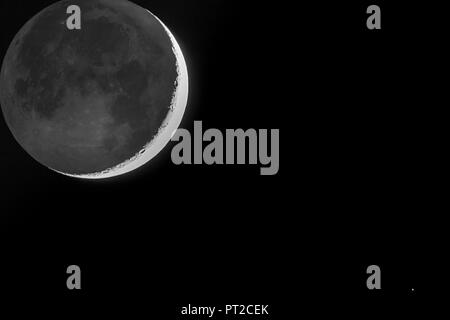 Germany, Hesse, Hochtaunuskreis, grey light and crescent of the moon with star Antares Stock Photo