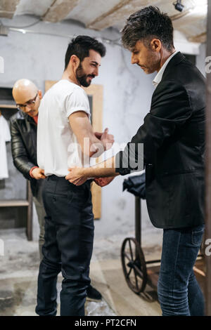 Model Guy Working Male design professional assisting fashion model during photo shoot in ...