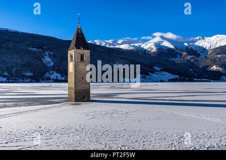 Europe, Italy, South Tyrol, Graun, Reschensee, Historic church tower in the frozen Reschensee in South Tyrol Stock Photo