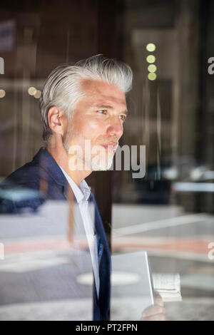 Portrait of a mature man, looking out of window Stock Photo