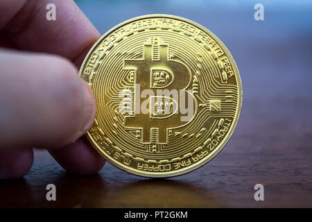 Hand holding a Golden bitcoin. Virtual money, Digital currency. Stock Photo