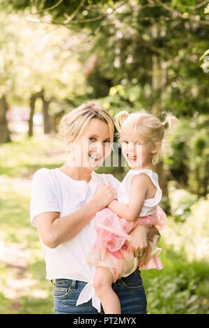 Portrait of happy mother and her little daughter in nature Stock Photo