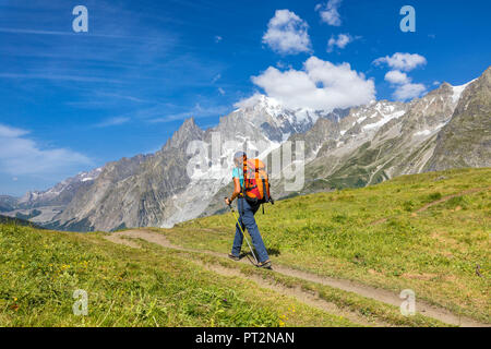A trekker is walking in front of the Mont Blanc during the Mont Blanc hiking tours (Ferret Valley, Courmayeur, Aosta province, Aosta Valley, Italy, Europe)
