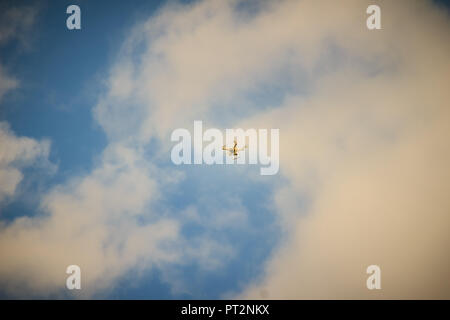 Far away of flying drone on cloudy blue sky and maybe it will out of control. Professional camera drone flying in blue sky and fully clouded. Abstract Stock Photo