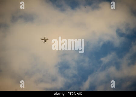Far away of flying drone on cloudy blue sky and maybe it will out of control. Professional camera drone flying in blue sky and fully clouded. Abstract Stock Photo