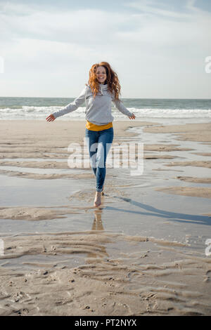 Happy woman having fun at the beach, running at the sea Stock Photo