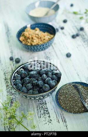 Bowls of blueberries, black chia seeds, granola  and amaranth Stock Photo