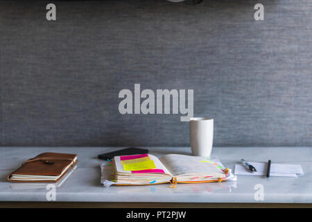 Notebooks, pen and coffee cup on shelf Stock Photo