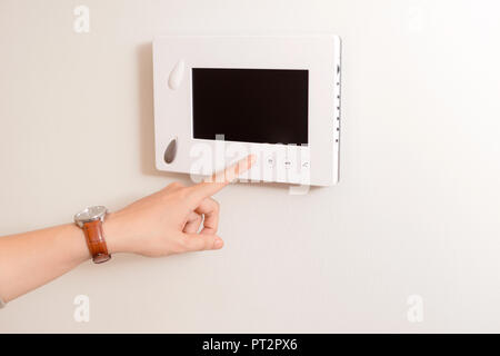 The handsome man opening door of the apartment using video door phone of intercom system. Stock Photo