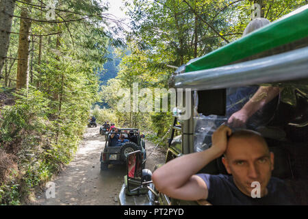 MIKULICZYN, UKRAINE - SEPTEMBER 14, 2018: Tourists take part in adventure extreme tour on quads, SUVs and truck to Carpathian Mountains. It is the sec Stock Photo