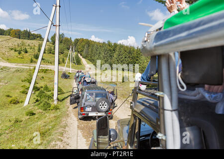 MIKULICZYN, UKRAINE - SEPTEMBER 14, 2018: Tourists take part in adventure extreme tour on quads, SUVs and truck to Carpathian Mountains. It is the sec Stock Photo