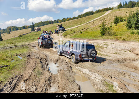 MIKULICZYN, UKRAINE - SEPTEMBER 14, 2018: Tourists take part in adventure extreme tour on quads and SUVs to Carpathian Mountains. It is the second lon Stock Photo