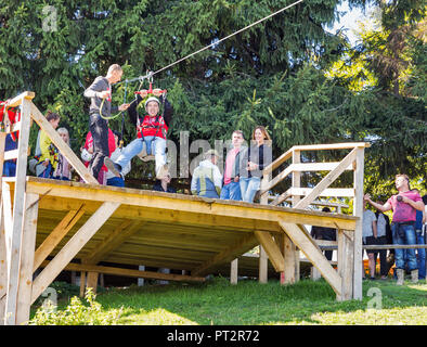 MIKULICZYN, UKRAINE - SEPTEMBER 14, 2018: People have fun on extreme cable downhill in Starishora mountain valley, Carpathian Mountains. Stock Photo