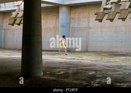 Young woman wearing yellow jeans clothes, walking Stock Photo