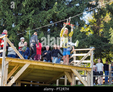 MIKULICZYN, UKRAINE - SEPTEMBER 14, 2018: People have fun on extreme cable downhill in Starishora mountain valley, Carpathian Mountains. Stock Photo