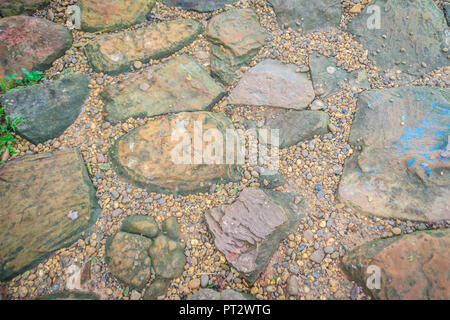 Vintage nature cobblestone and pebbles pavement in disorganized arrangement pattern background. Paving blocks made of nature asymmetrical stone backgr Stock Photo