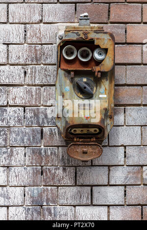 An old fuse box with a switch urgently needed to be replaced. Stock Photo