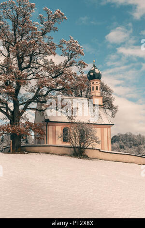 St.Georg Chapel at Murnau in wintry landscape, blue sky Stock Photo