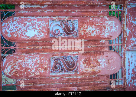 Old wrought iron bars on the gate with grunge and rusty steel  background. Iron Grill Ornamental Flourish Detail Background. The old rusty fence with  Stock Photo