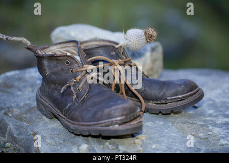 Old hiking boots on a rock Stock Photo