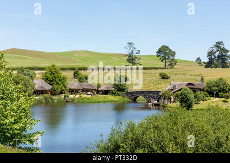 Lake, bridge and The Green Dragon Inn, Hobbiton Movie Set, Matamata, Waikato region, North Island, New Zealand, Stock Photo