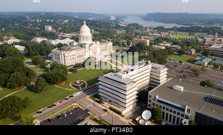 The State Capitol of Little Rock stands lit by bright sunshine near dusk Arkansas River in the background Stock Photo