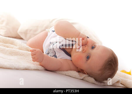 baby boy 7 months old, lying on the ground, Germany, Stock Photo