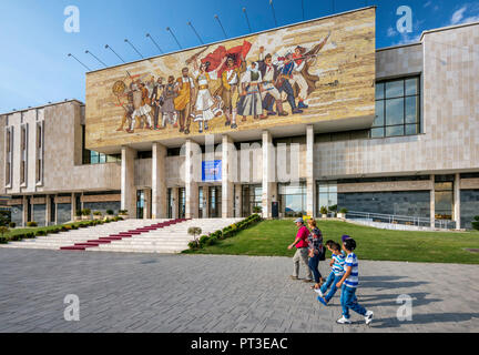 Communist era mosaic at National Historical Museum, passersby, at Skanderbeg square in Tirana, Albania Stock Photo