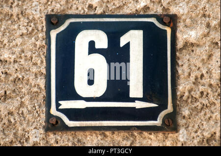 Weathered grunge square metal enameled plate of number of street address with number 61 closeup Stock Photo