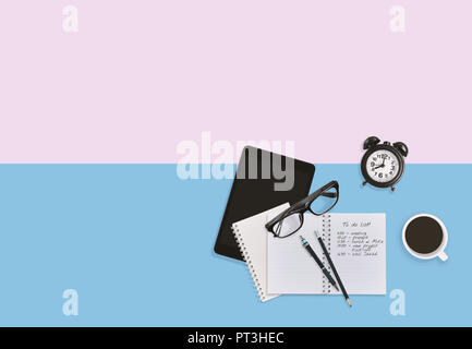 Top view of personal business man workplace desktop in pastel background with notebook, notes, eyeglasses, tablet, pencils and a cup of black coffee w Stock Photo