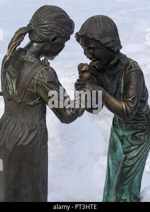 Girl and boy eating ice cream bronze statue outside ENMAX Conservatory at Calgary Zoo Stock Photo