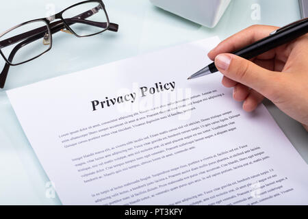 Close-up Of A Woman's Hand Holding Pen Over Privacy Policy Form Stock Photo