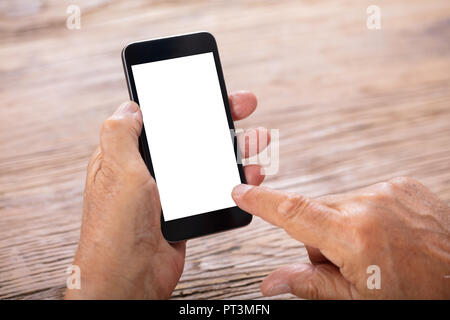 Senior Man Holding Mobile Phone With Blank White Screen Stock Photo