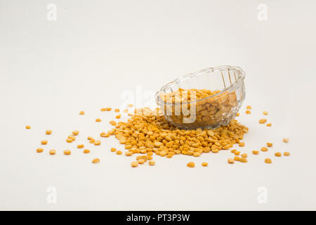 Yellow split peas in transparent bowl isolated on white background. Stock Photo