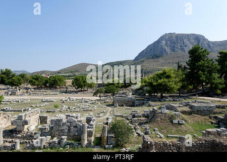 View over the northwest stoa and forum ruins. The limestone mountain of Acrocorinth is in the background. Ancient Corinth, Peloponnese, Greece. Stock Photo