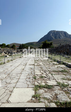 The paved Lechaion road or way, once the main thoroughfare from the Agora to the harbour. Ancient Corinth. Peloponnese. Greece. The 12 metres wide mar Stock Photo