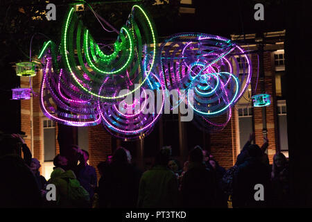People stood under colourful decorative neon lights at Leeds Light, West Yorkshire, England, UK. Stock Photo