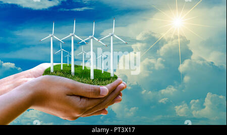 wind turbine hand Alternative energy businessman hand holding landscape with eco wind turbine concept Stock Photo