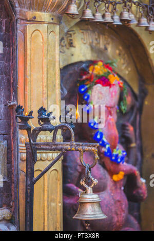 Hindu God with Bells and Holy lamps in the Temple Stock Photo