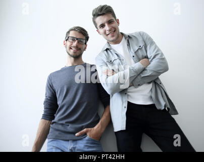 Cheerful man laughing and looking at camera with a big grin. Portrait of a happy young man standing over grey background Stock Photo