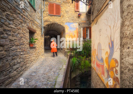 Women looks murales in a street Apricale, Province of Imperia, Liguria, Italy, Europe, Stock Photo
