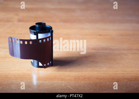 A roll of 35 mm film for cameras on wooden table Stock Photo