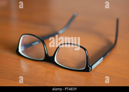 Eyeglasses on wooden table Stock Photo