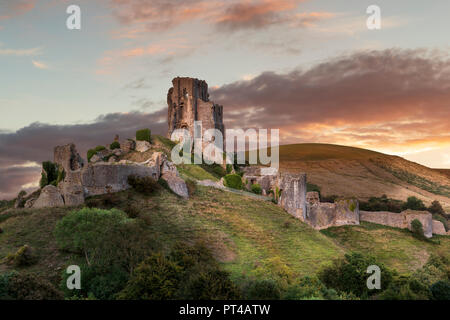 The sun lights up the ancient remains of Corfe Castle in Dorset. Stock Photo