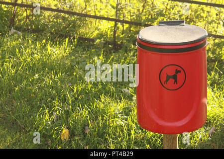 Red dog waste bin in the countryside Stock Photo