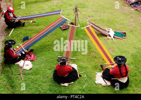 Female alpaca weavers weaving fabrics in the traditional way near Machu Picchu in Chincheros Stock Photo