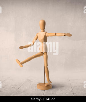 Wooden mannequin posed in front of a greyish background Stock Photo